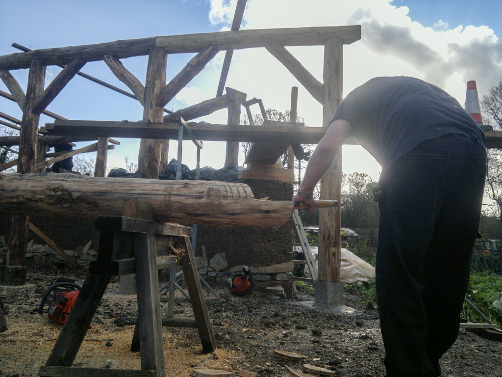 LandWorks trainee chiselling the join on the end. Timber frame land art sculpture