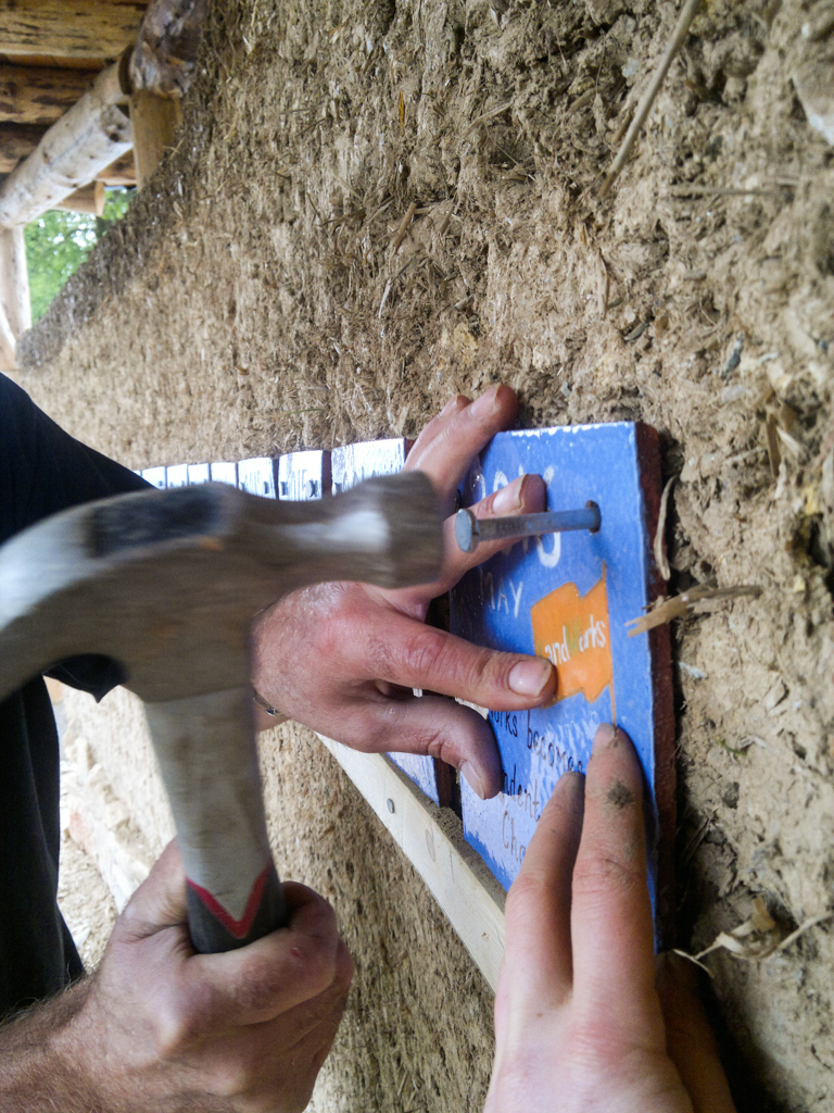 Tense moments of attaching tiles onto the wall - and one very patient LandWorks trainee!